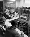 Vintage black and white photo of a bakery with customers and staff at Cooper Donuts